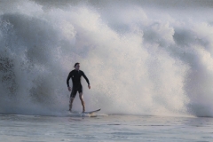 Surfer-with-large-breaking-wave-behind-him